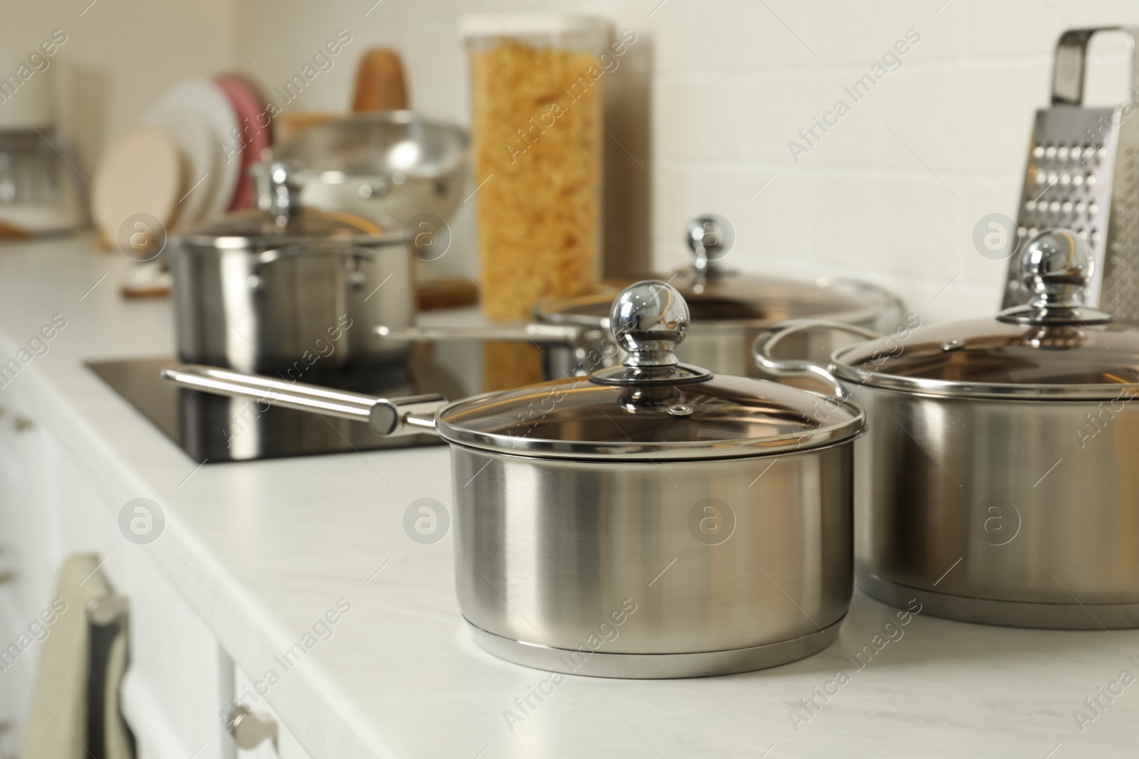 Photo of Pot and saucepan on kitchen counter. Cooking utensils