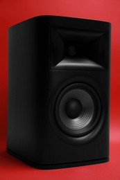Photo of One wooden sound speaker on red background