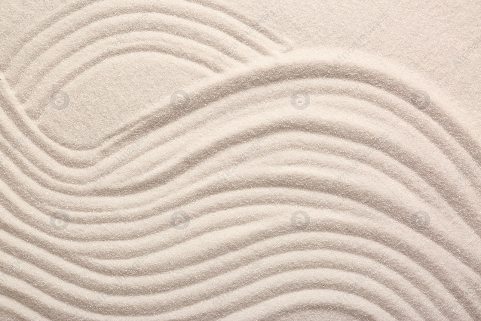 Photo of White sand with pattern as background, top view. Zen concept