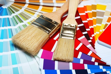 Photo of Closeup view of brushes and paint color palette samples
