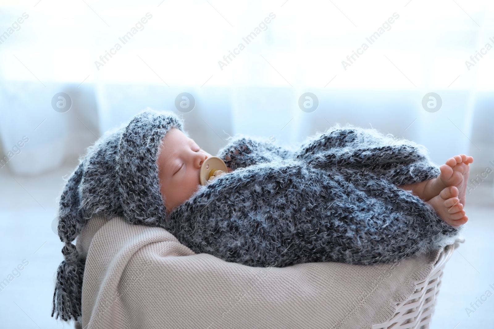 Photo of Cute newborn baby sleeping in basket at home