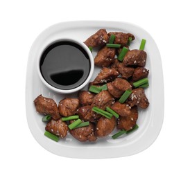 Plate with tasty soy sauce, roasted meat, sesame and green onion isolated on white, top view