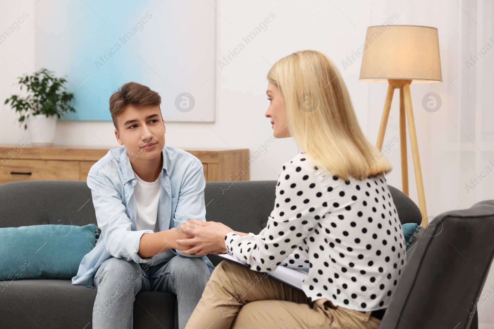 Photo of Psychologist working with teenage boy in office