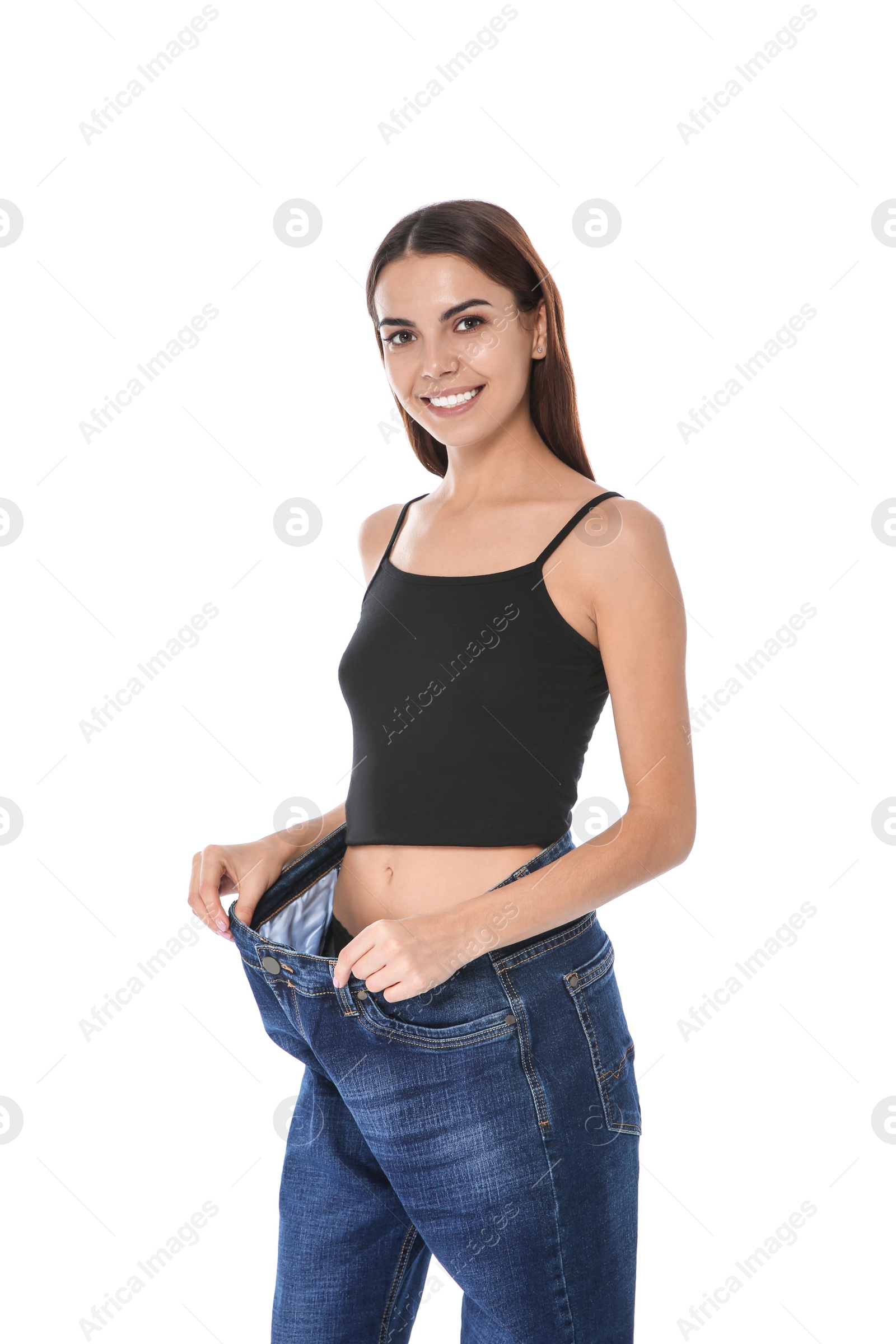 Photo of Slim woman in oversized jeans on white background. Weight loss