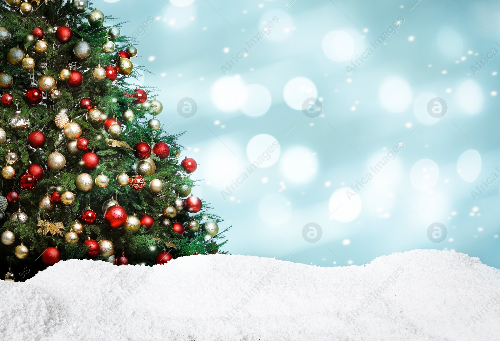 Image of Beautifully decorated Christmas tree and snow on light blue background, space for text. Bokeh effect