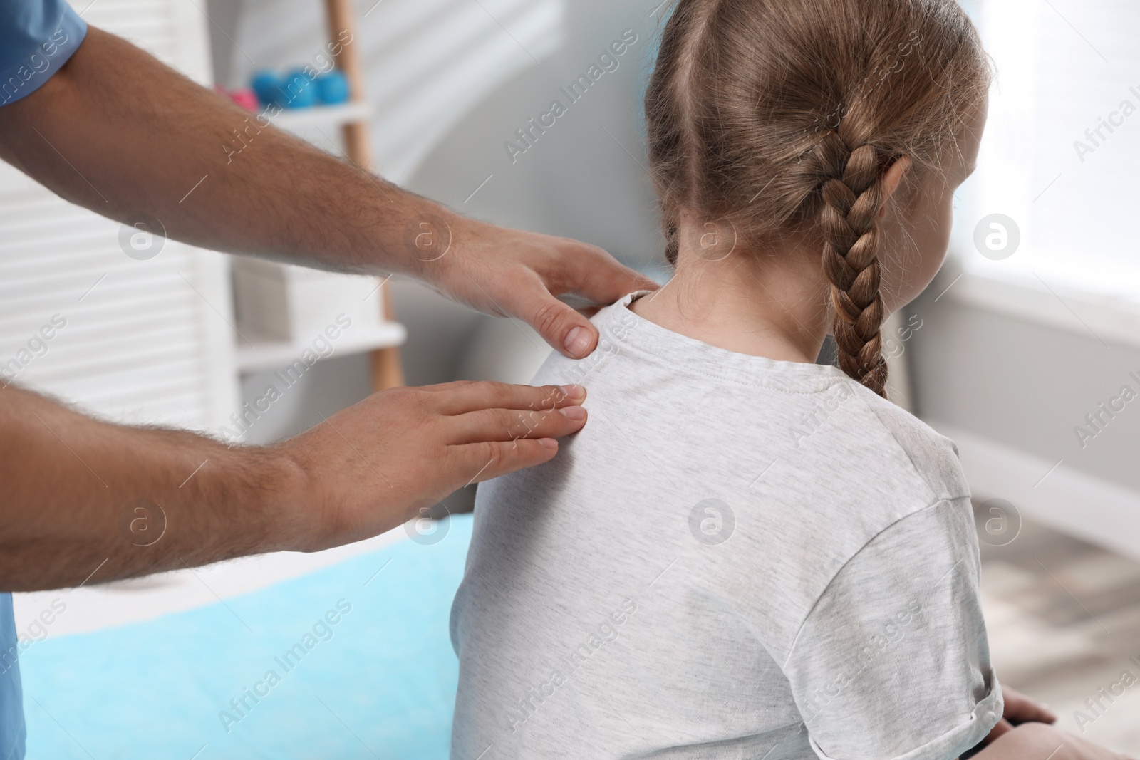 Photo of Orthopedist examining child's back in clinic, closeup. Scoliosis treatment