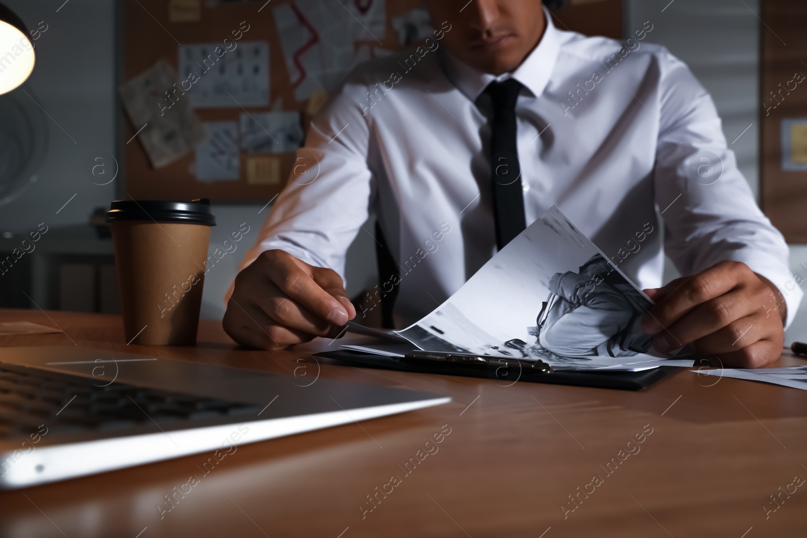 Photo of Detective working at desk in his office, closeup