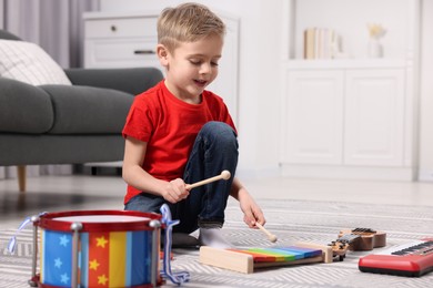 Photo of Little boy playing toy xylophone at home