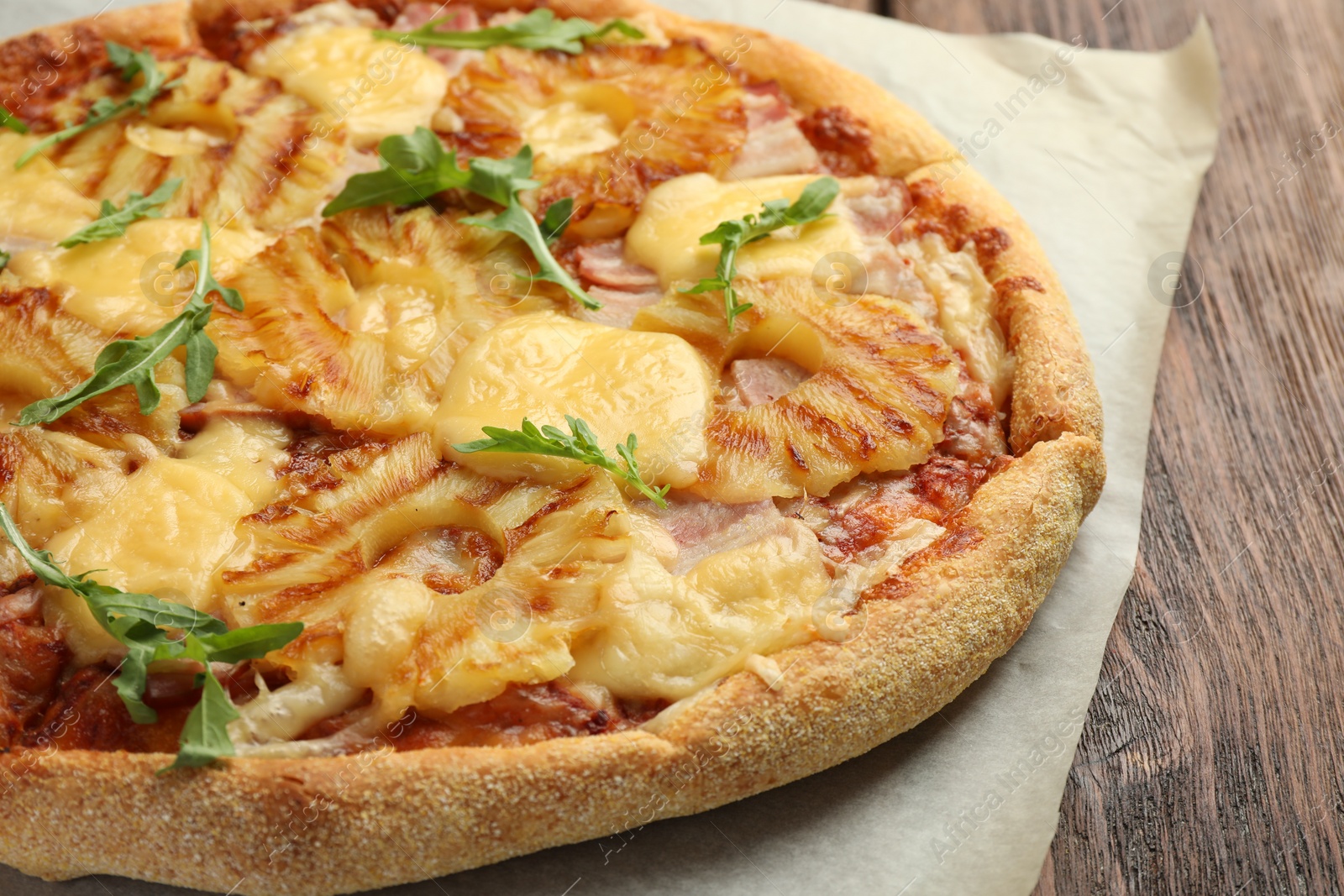 Photo of Delicious pineapple pizza with arugula on table, closeup