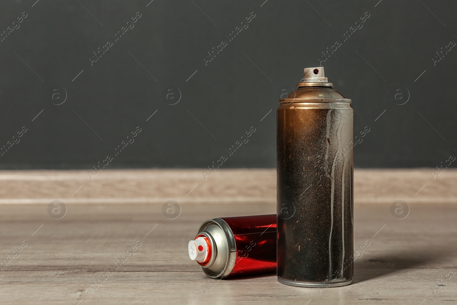 Photo of Used cans of spray paint on floor indoors. Space for text