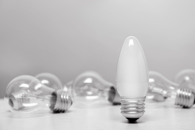 Frosted and transparent lamp bulbs on table. Space for text