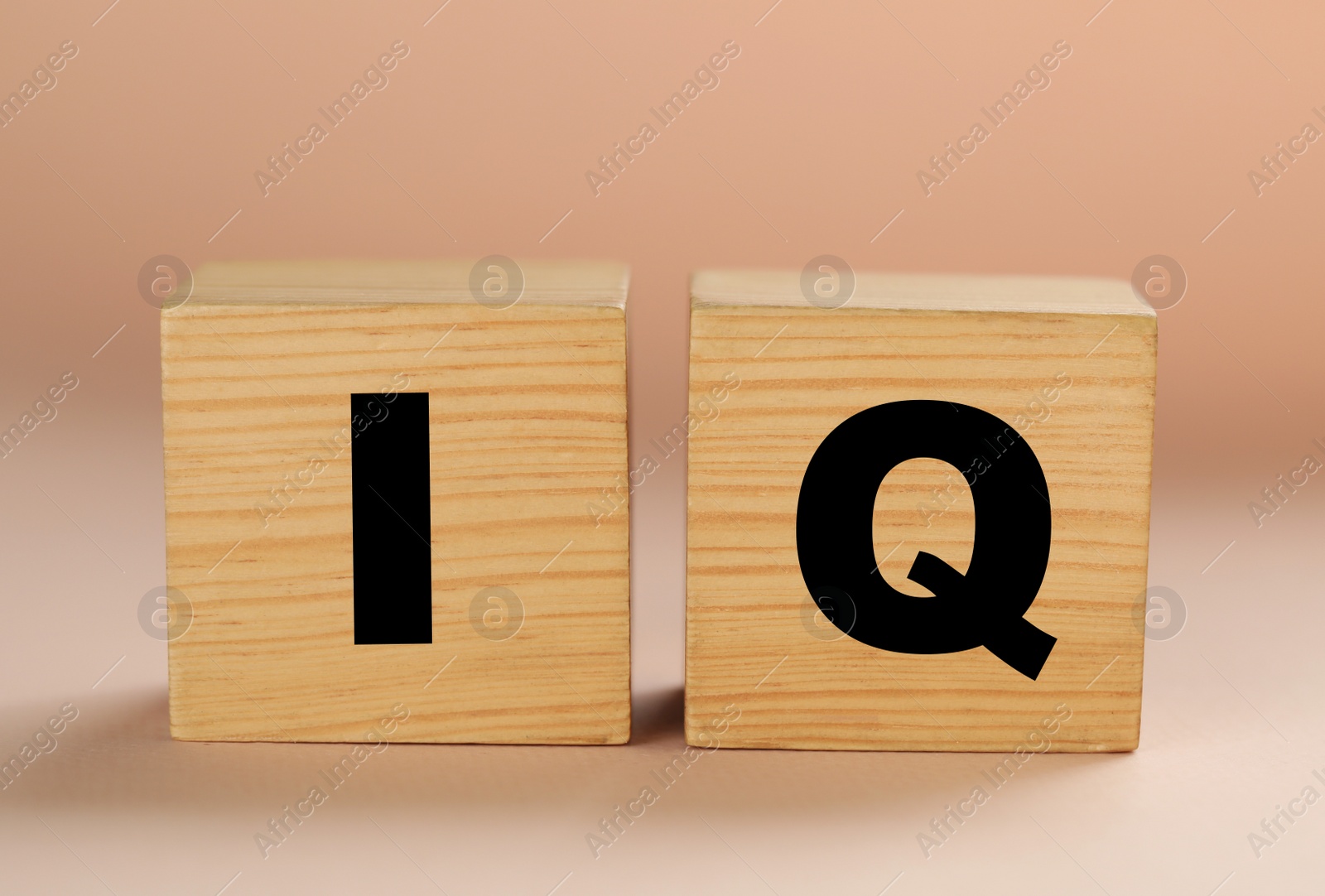 Photo of Wooden cubes with abbreviation IQ on beige background