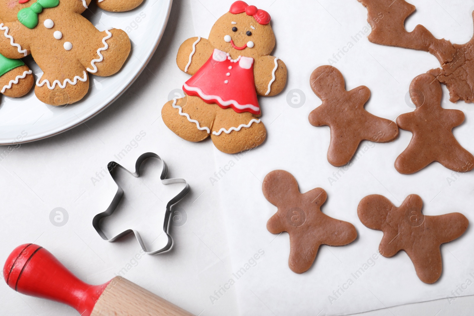 Photo of Flat lay composition with homemade gingerbread man cookies on light table