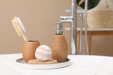 Photo of Different personal care products and accessories on bath tub in bathroom, closeup