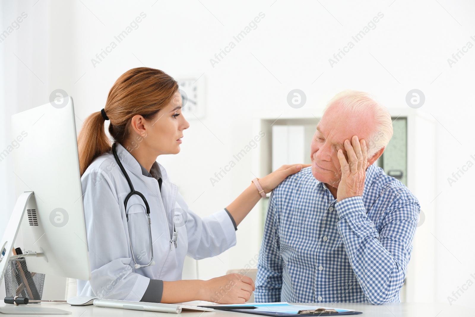 Photo of Doctor comforting upset elderly patient in hospital