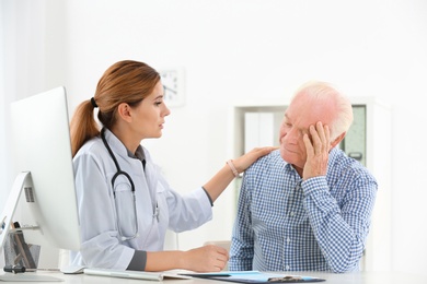 Photo of Doctor comforting upset elderly patient in hospital