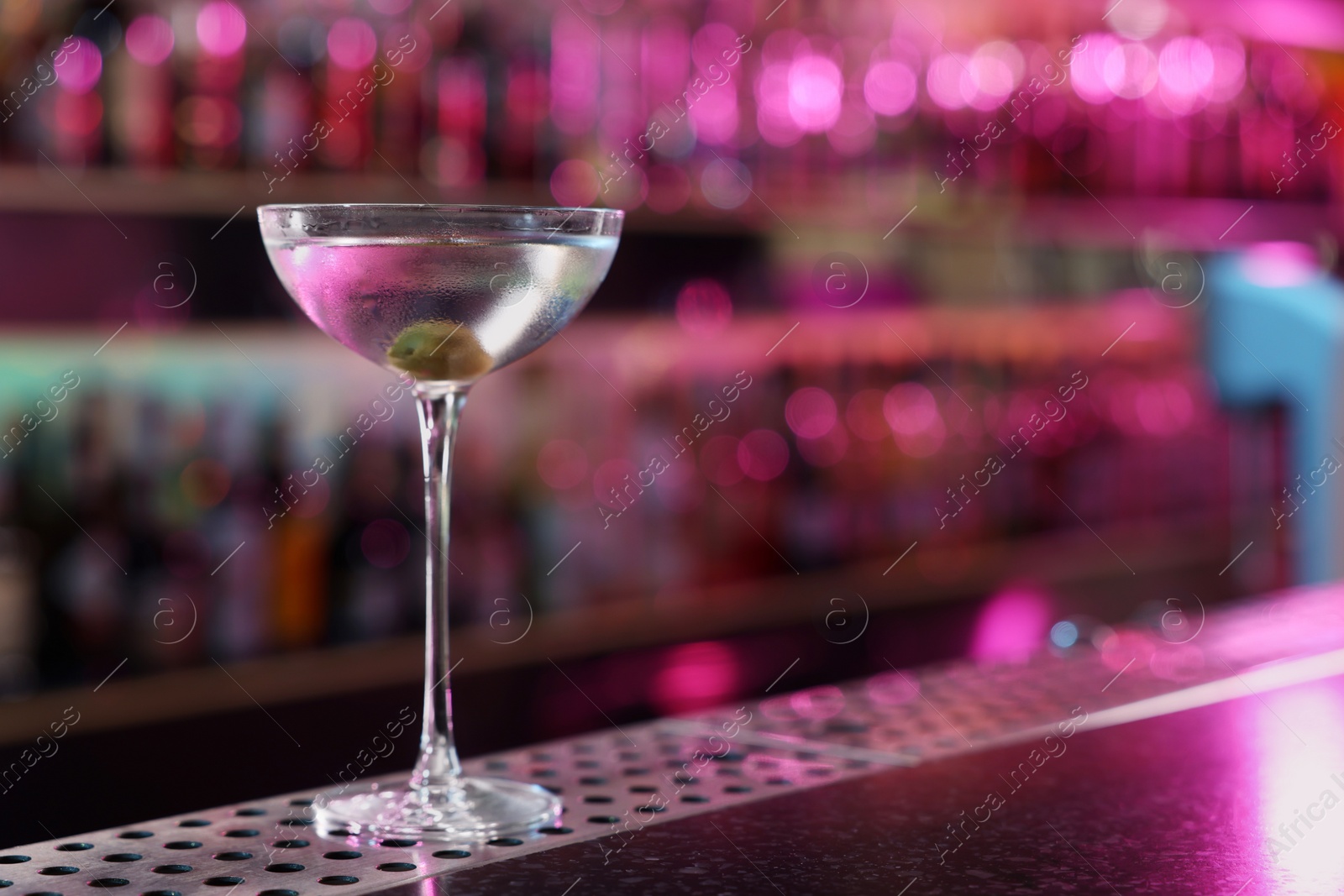 Photo of Fresh Martini cocktail on counter in bar. Space for text