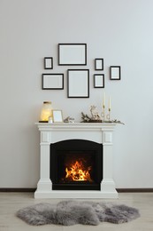 Photo of Stylish interior decorations on fireplace near white wall indoors
