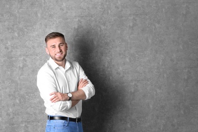 Portrait of handsome happy man on grey background, space for text