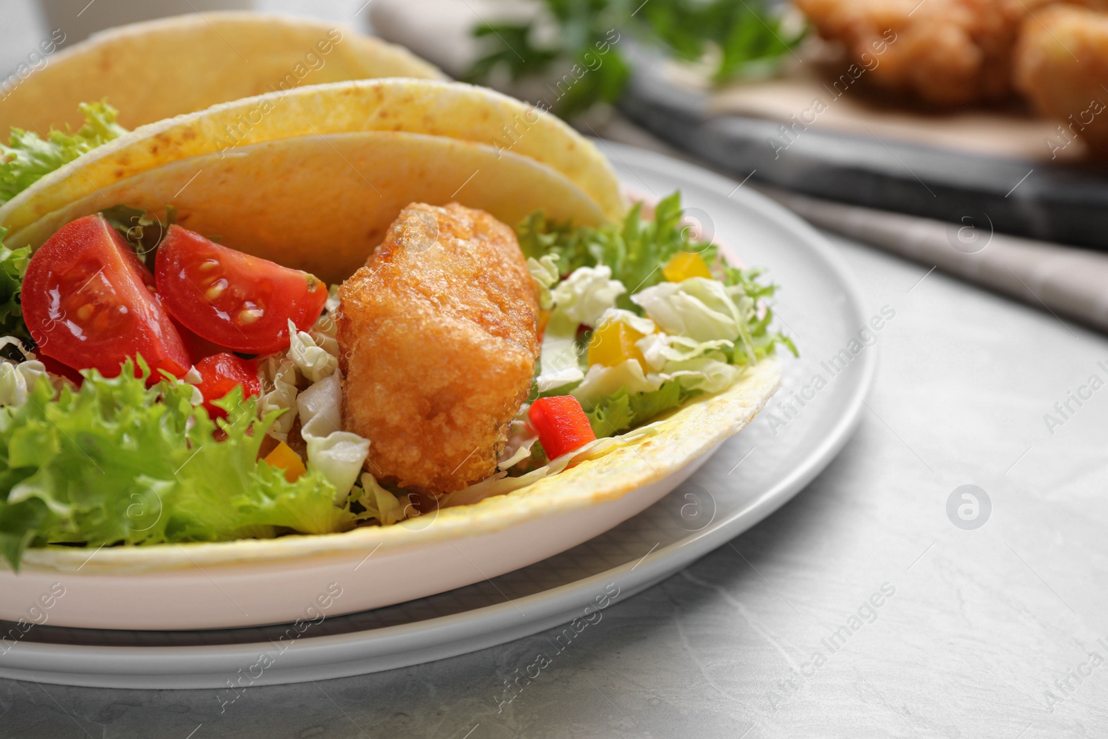 Photo of Delicious fish tacos served on marble table, closeup