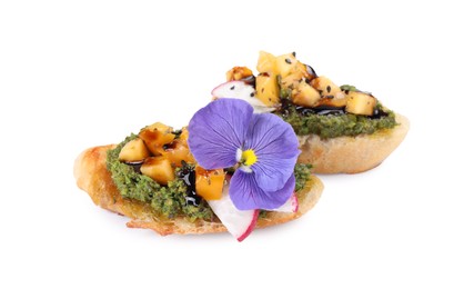 Photo of Delicious bruschettas with pesto sauce, tomatoes, balsamic vinegar and violet flower isolated on white