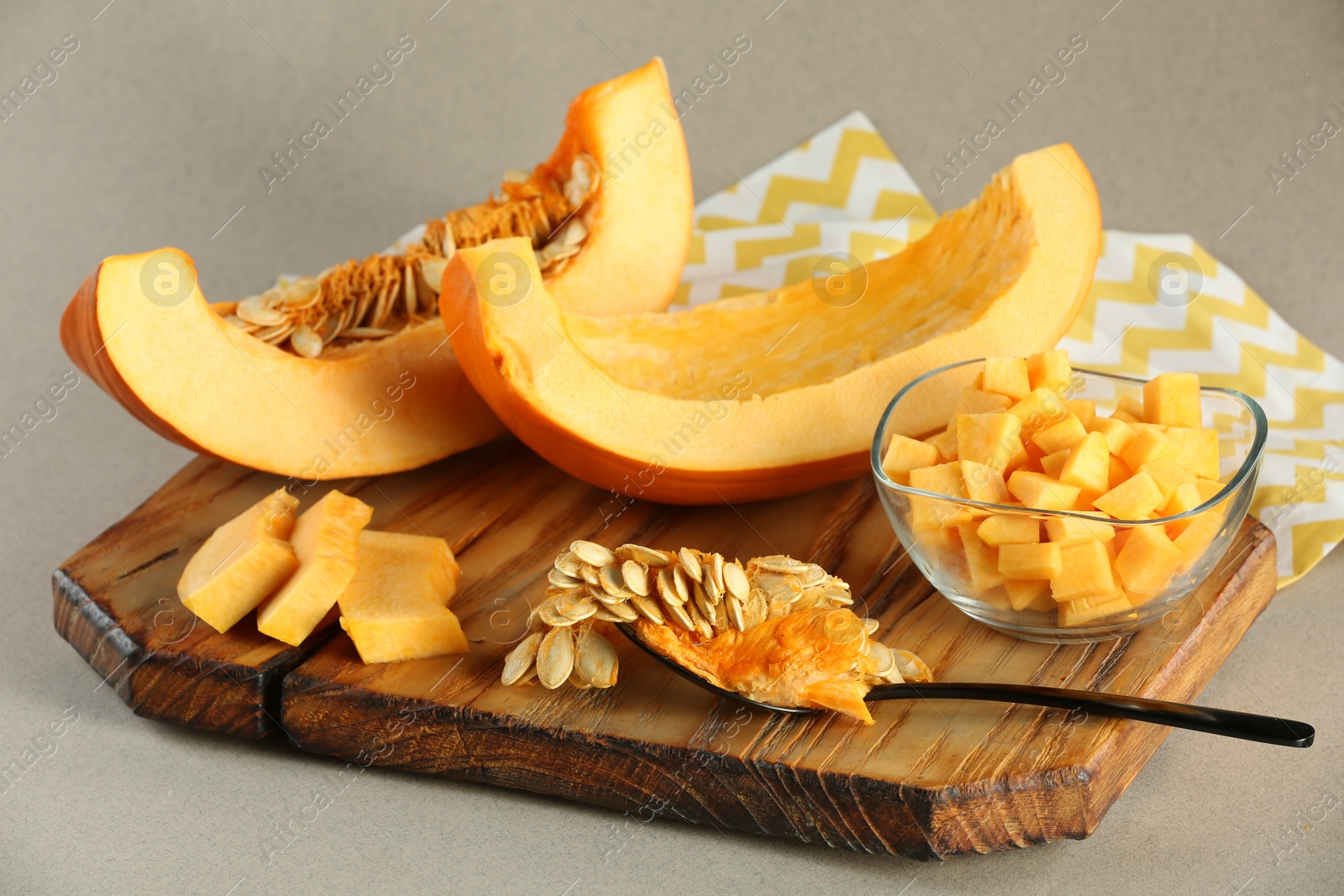 Photo of Cut fresh ripe pumpkin on grey background