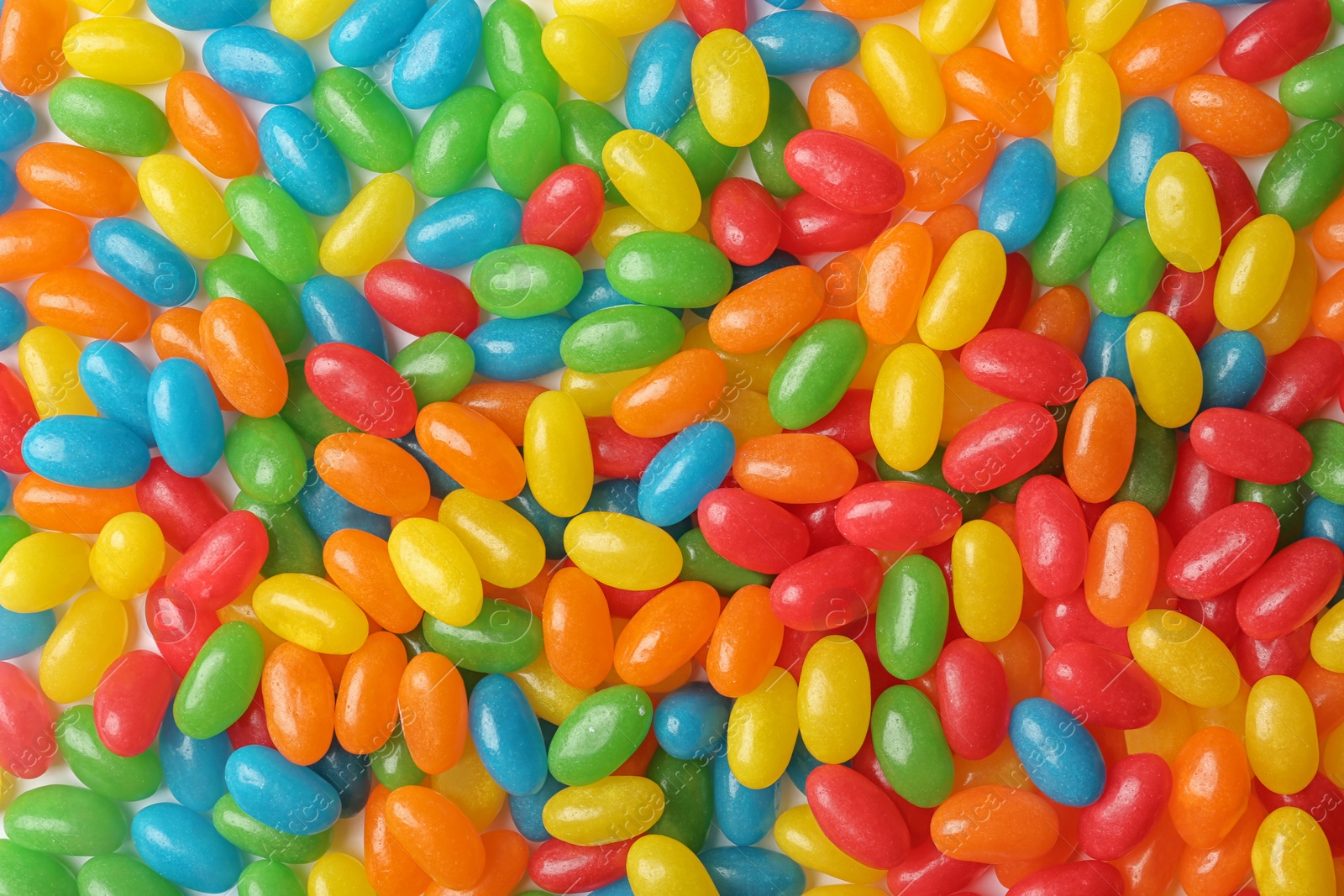 Photo of Tasty bright jelly beans as background, top view