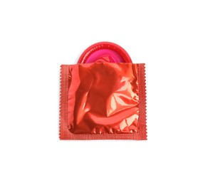 Photo of Unpacked red condom isolated on white, top view. Safe sex