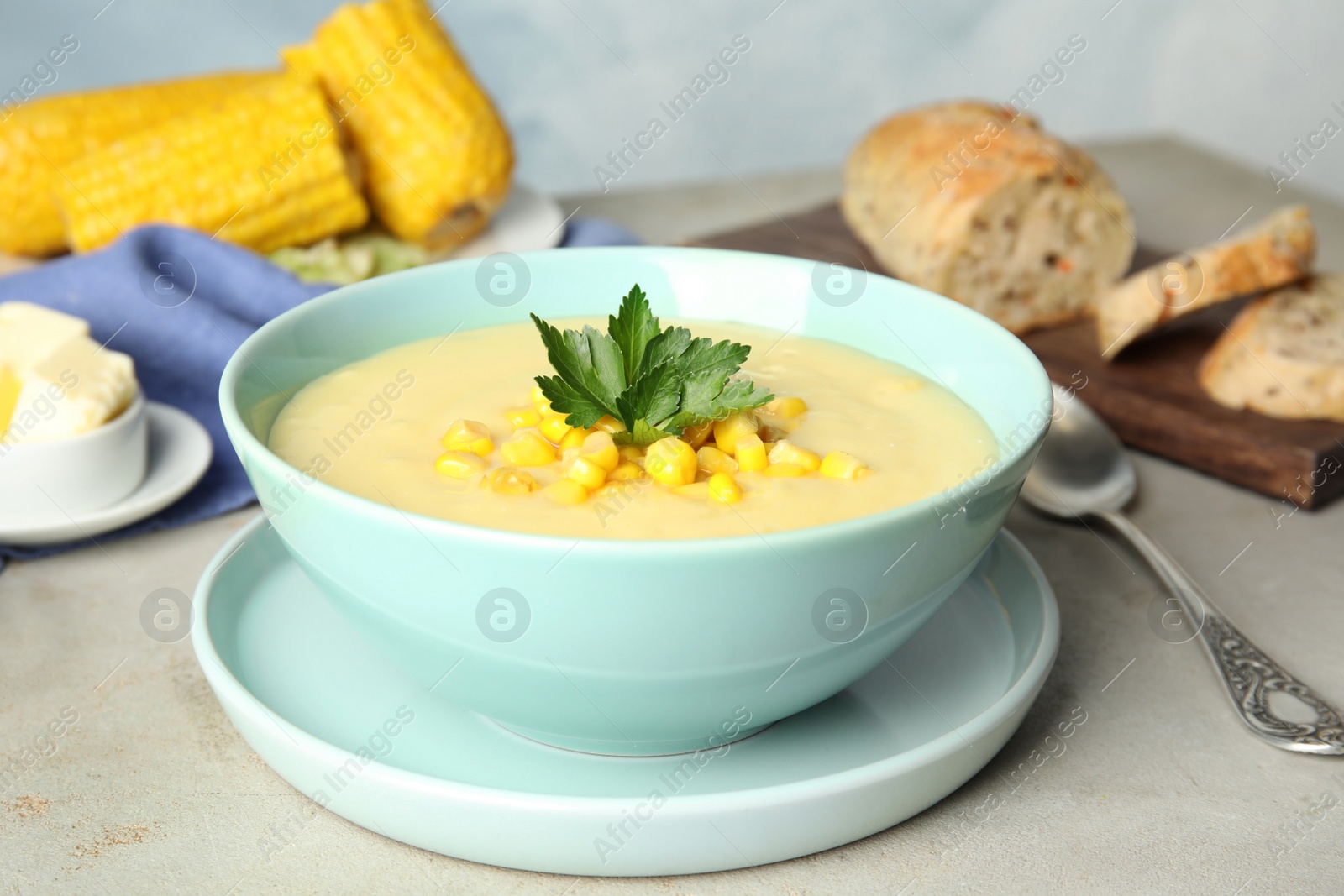 Photo of Delicious corn cream soup served on light grey table