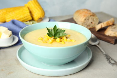 Photo of Delicious corn cream soup served on light grey table