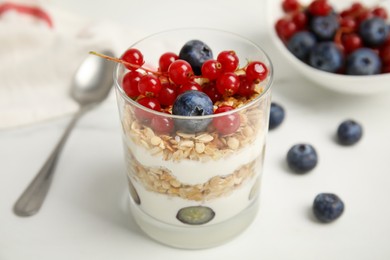 Photo of Delicious yogurt parfait with fresh berries on white table, closeup