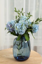 Photo of Beautiful blue hortensia flowers in vase on table indoors