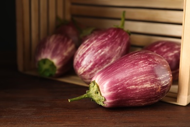Photo of Ripe purple eggplants on wooden table, closeup
