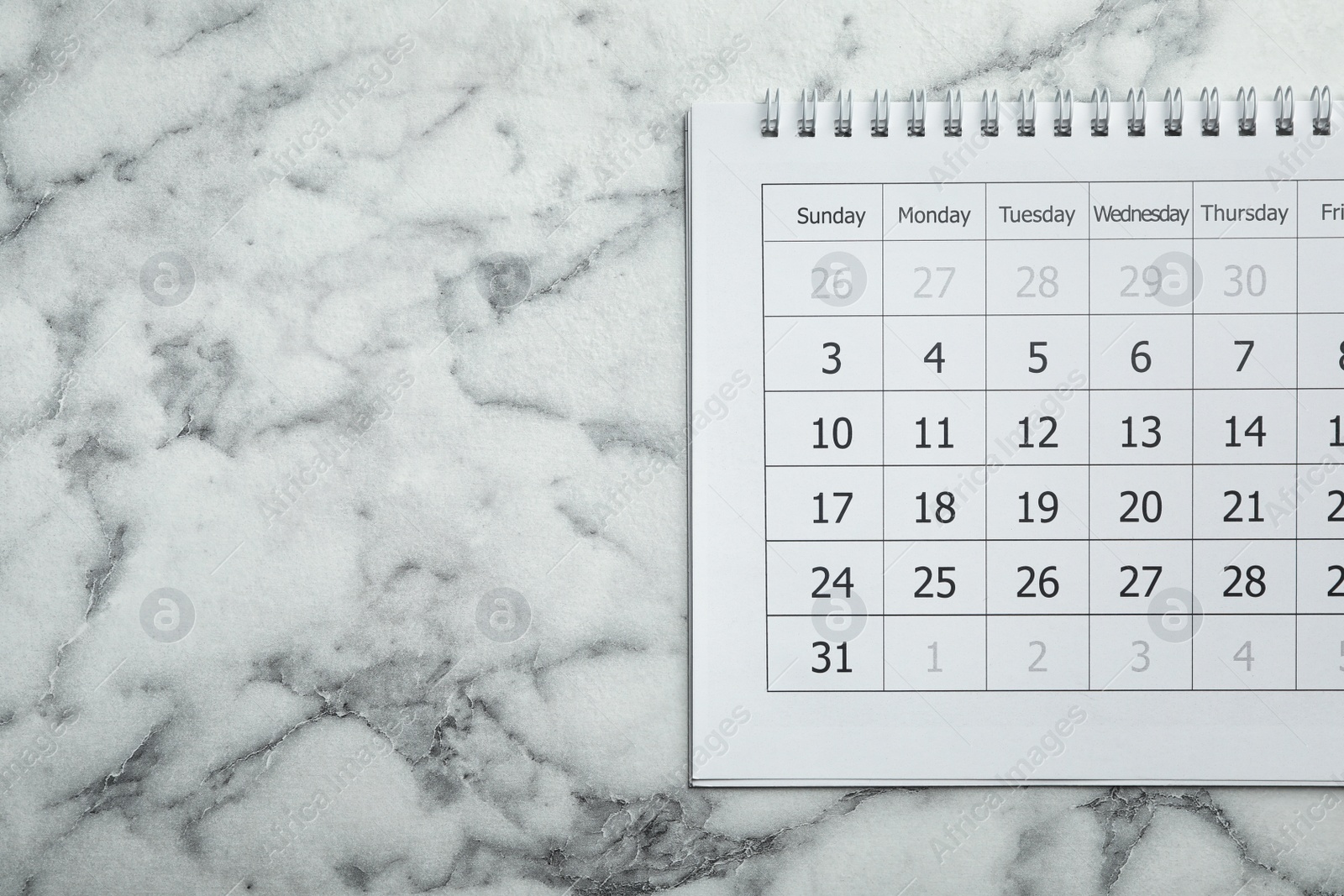 Photo of Paper calendar on marble background, top view. Space for text