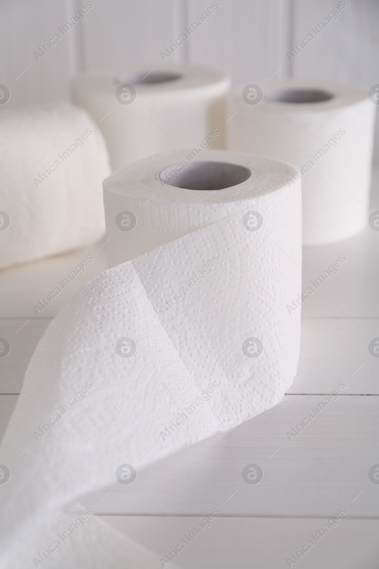 Photo of Soft toilet paper rolls on white wooden table