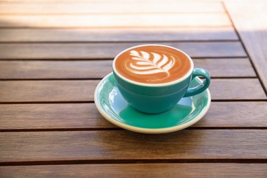 Cup of aromatic hot coffee on wooden table, space for text