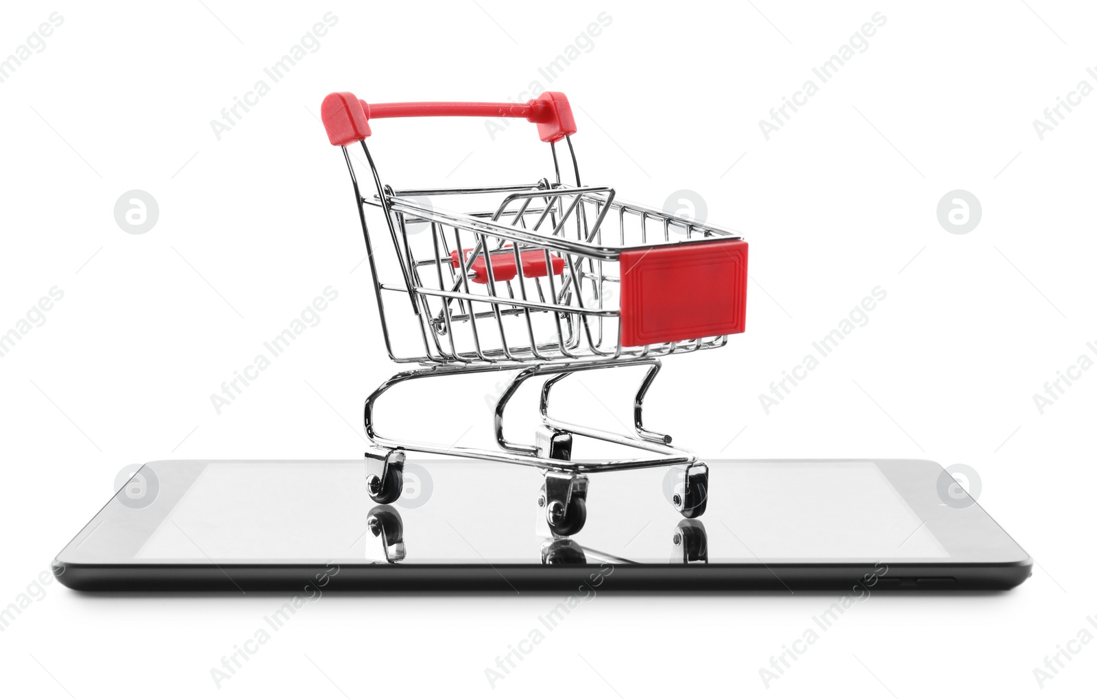 Photo of Internet shopping. Small cart and modern tablet on white background