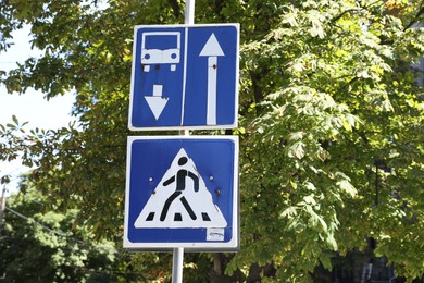 Photo of Forward one-way street with reverse lane for public transport and Pedestrian crossing road signs outdoors