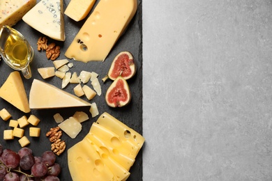 Photo of Different delicious cheeses served on grey table, top view. Space for text