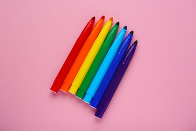 Photo of Many different colorful markers on light pink background, flat lay
