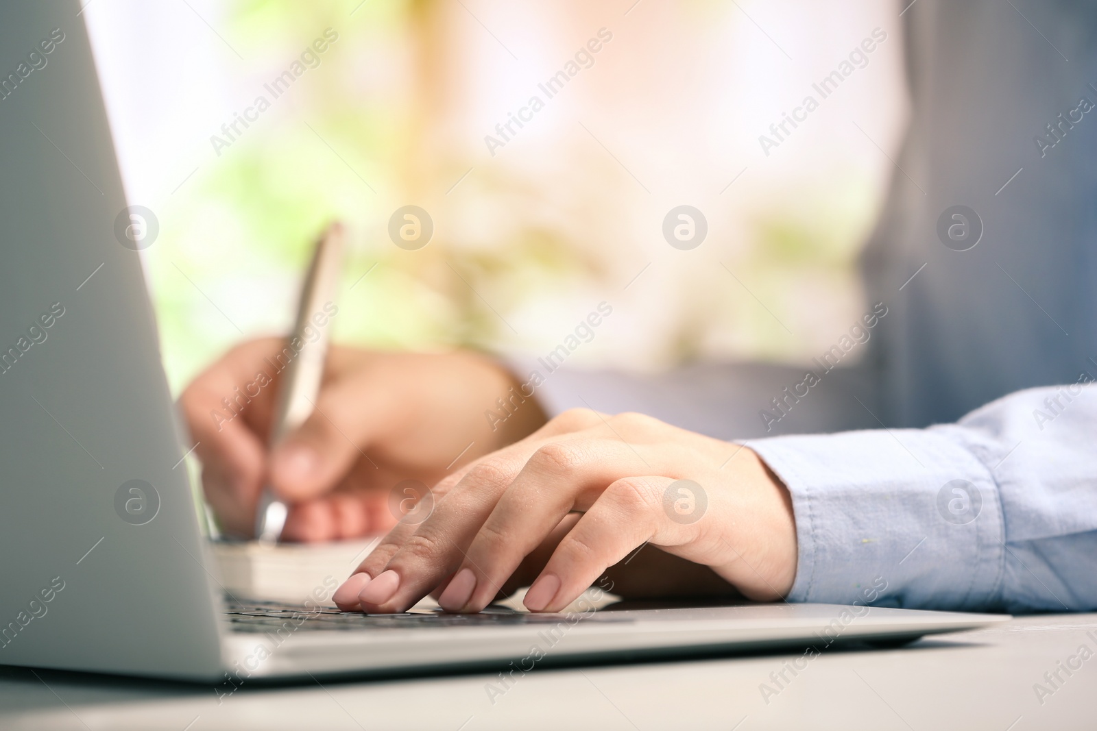 Image of Journalist working with laptop at table, closeup