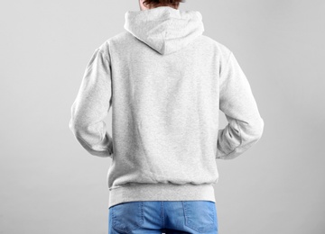 Photo of Man in hoodie sweater on light background. Space for design