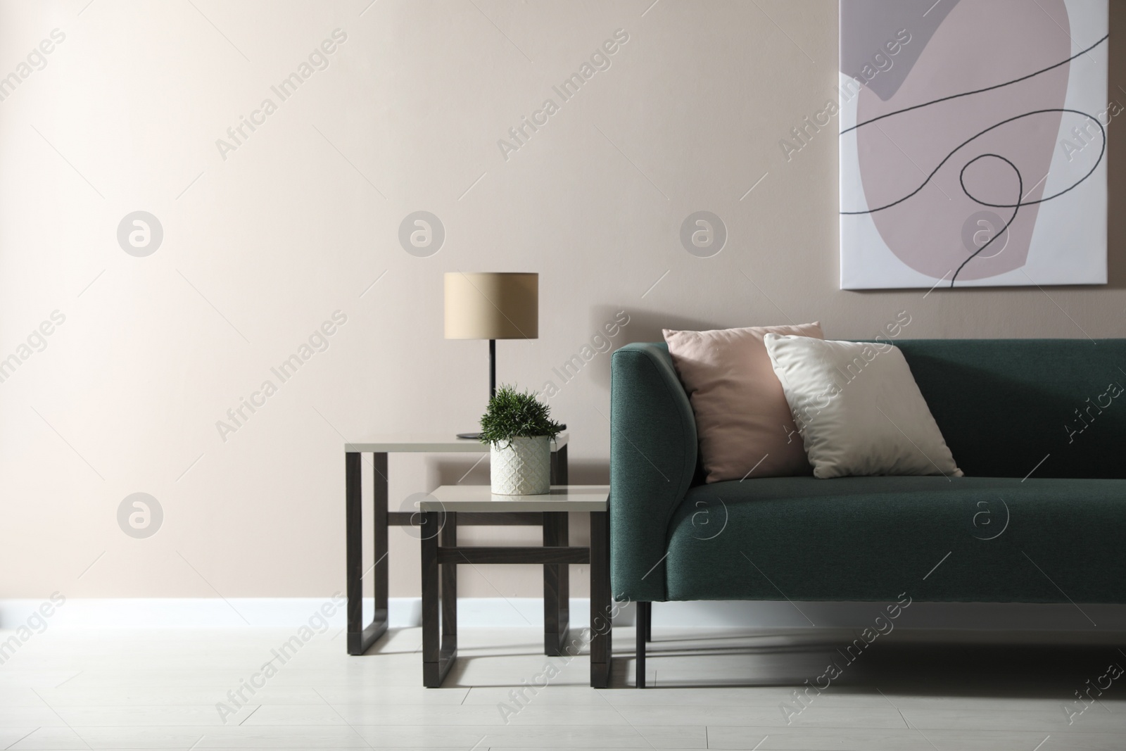 Photo of Stylish living room interior with comfortable green sofa and beautiful plant. Space for text