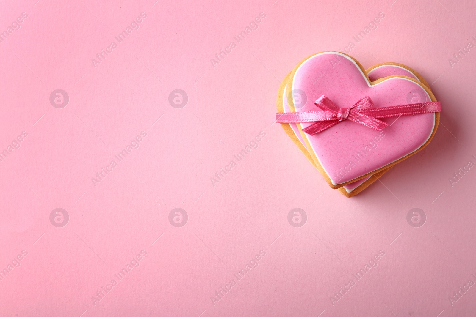 Photo of Decorated heart shaped cookies and space for text on color background, top view