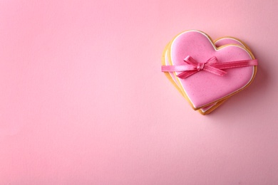 Decorated heart shaped cookies and space for text on color background, top view