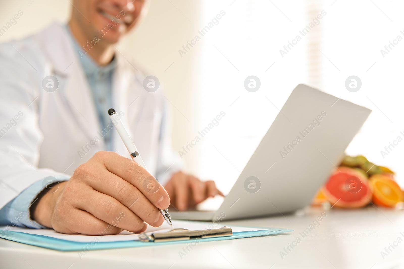 Photo of Nutritionist working at desk in office, closeup