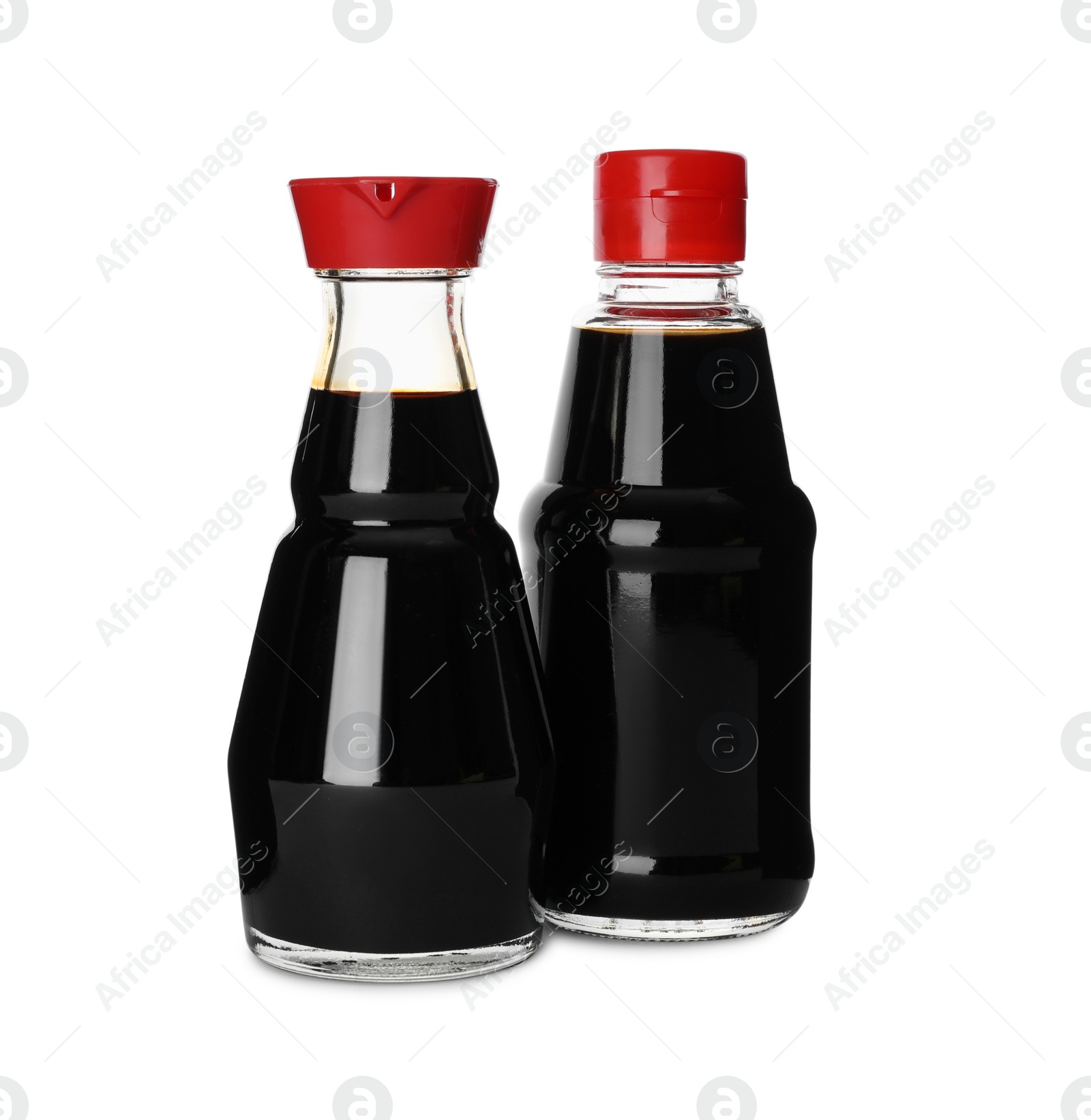 Photo of Bottles of tasty soy sauce isolated on white