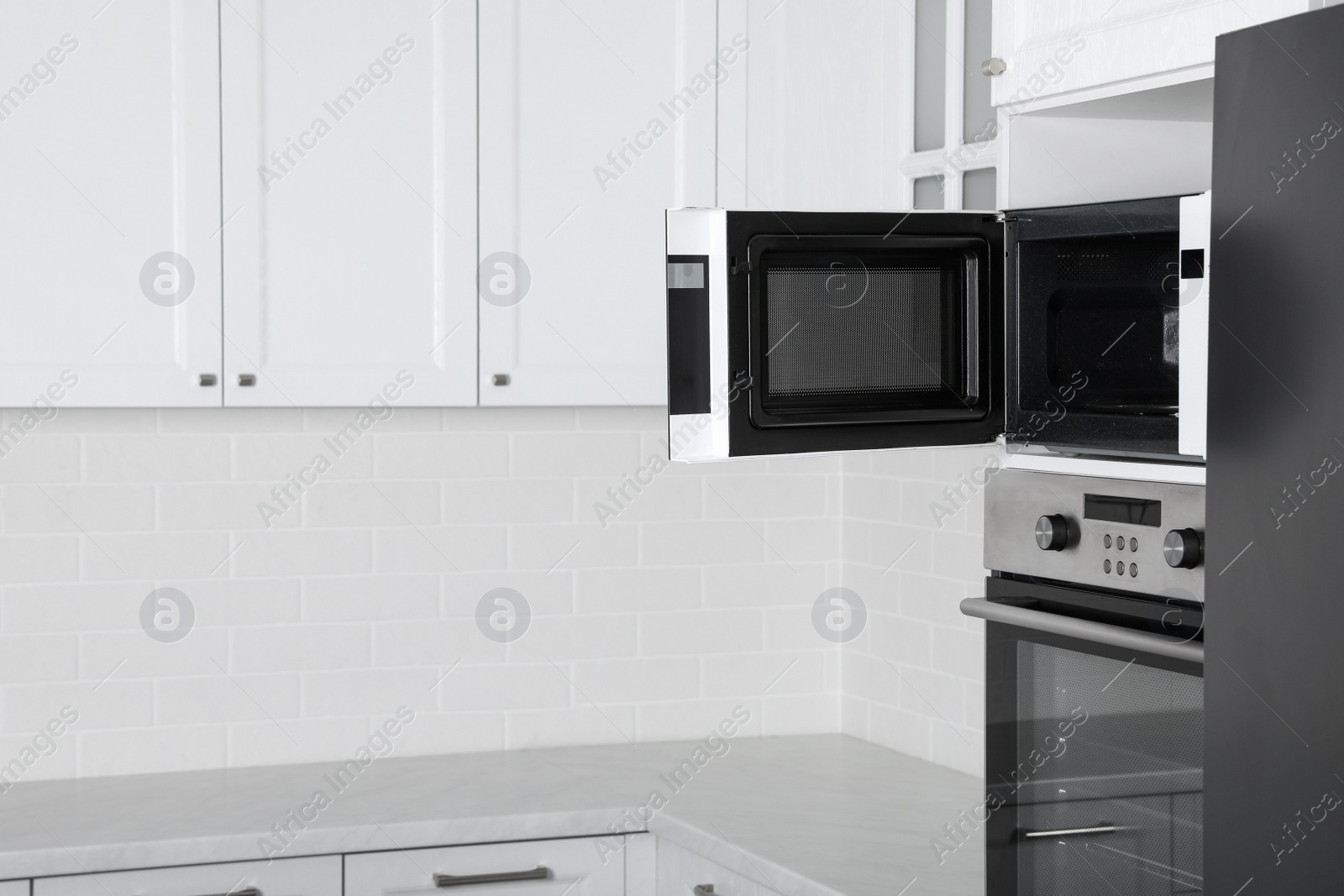 Photo of Modern oven and microwave in white clean kitchen