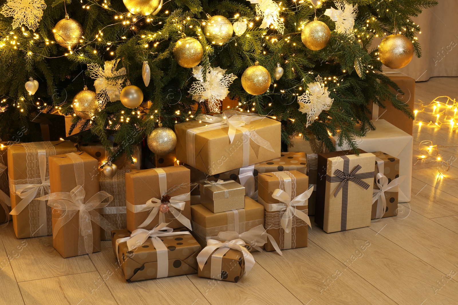 Photo of Many gift boxes under decorated Christmas tree at home