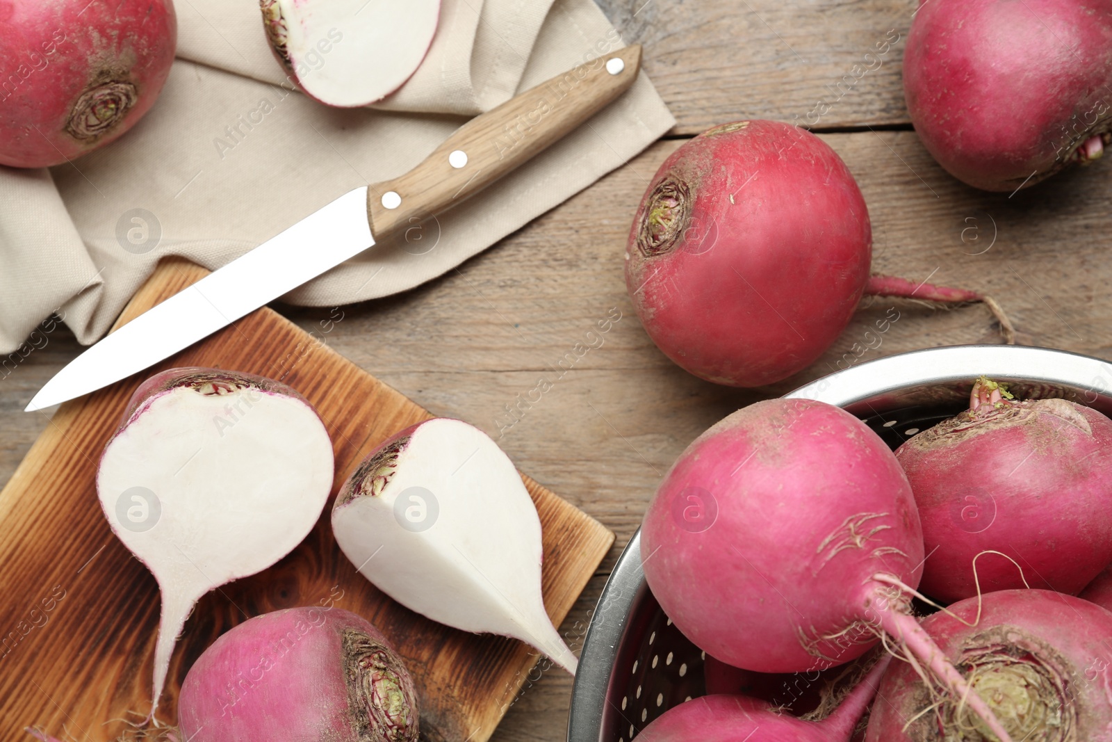 Photo of Red turnips and knife on wooden table, flat lay